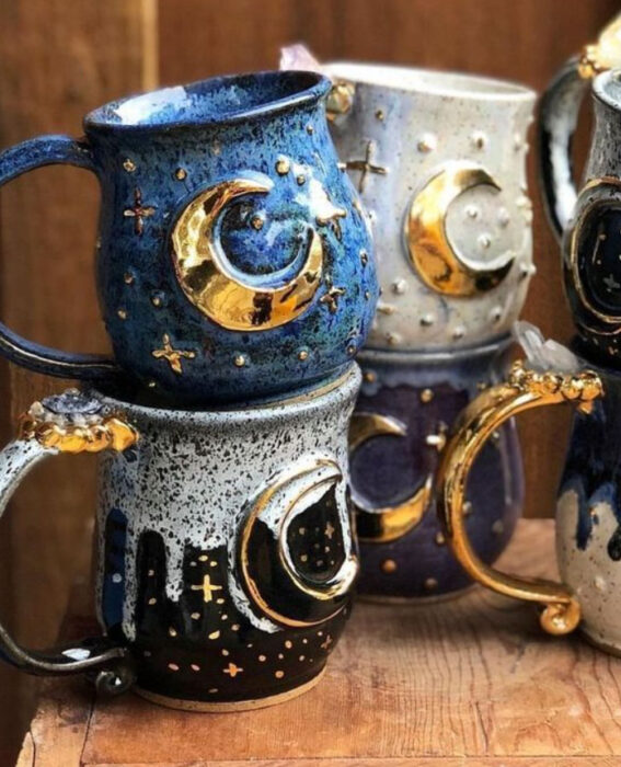 Tazas de diferentes colores con la silueta de la Luna en color dorado