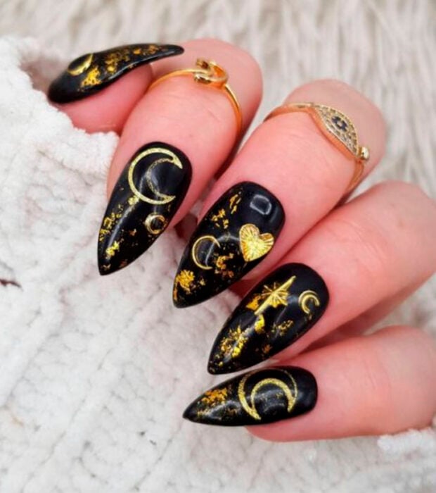 Manicura inspirada en noche de brujas de fondo color negro con detalles en color dorado