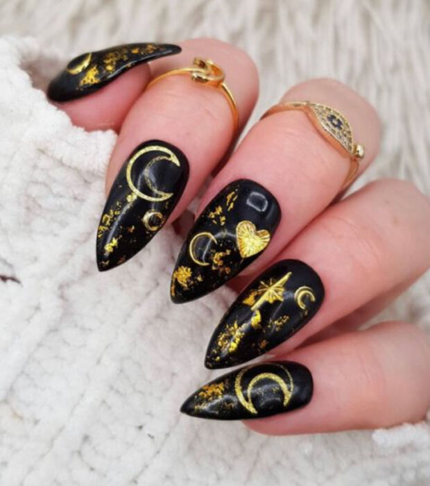 Manicura inspirada en noche de brujas de fondo color negro con detalles en color dorado