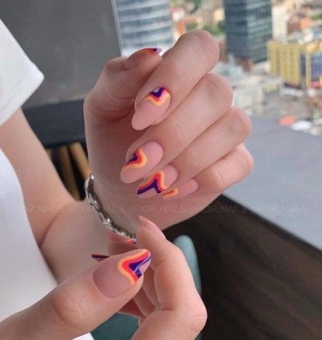 Manicura de acrílico estilo aesthetic con fondo nude y líneas de diferentes colores