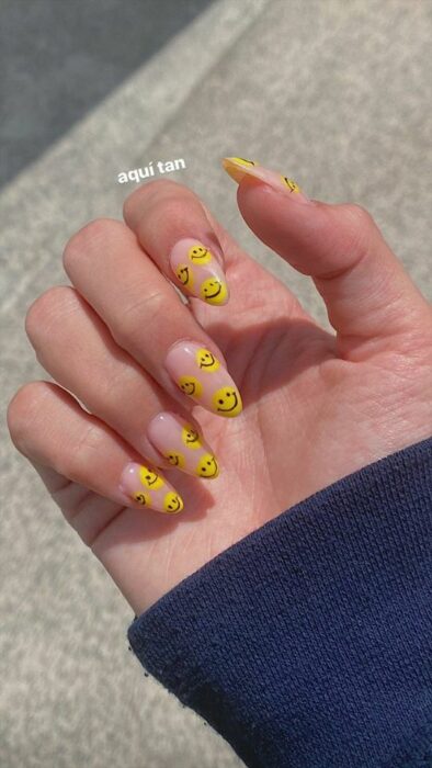 Manicura de acrílico estilo aesthetic con diseño de caritas felices en color amarillo