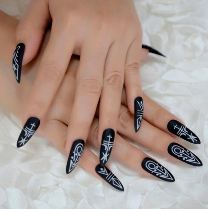 Manicura inspirada en noche de brujas de fondo color negro con detalles en color blanco