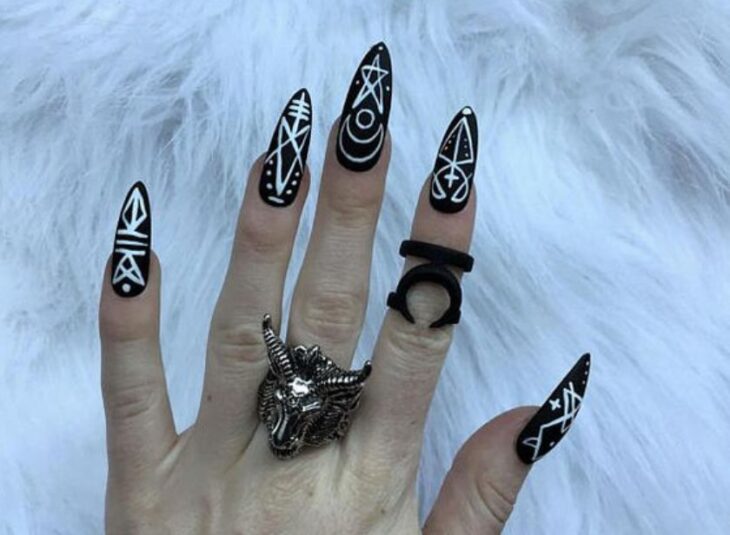 Manicura inspirada en noche de brujas de fondo negro con detalles en color blanco