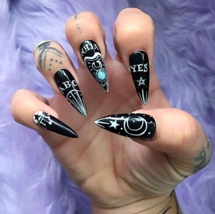 Manicura inspirada en noche de brujas de color negro con detalles en color blanco