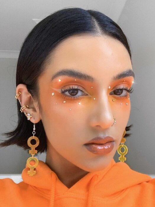 Maquillaje creativo con colores naranja y blanco