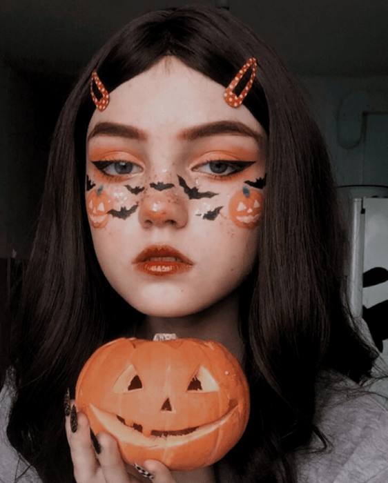 Chica con maquillaje en colores naranjas inspirados en Halloween