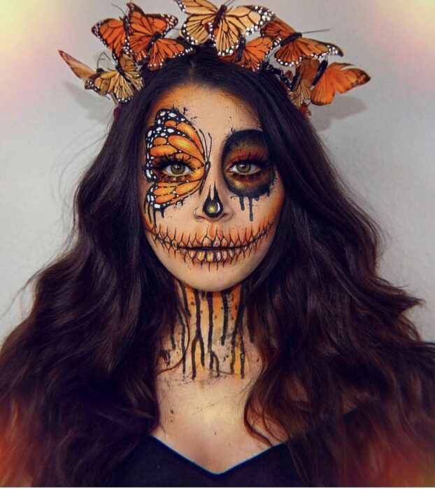 Chica con un maquillaje de catrina en colores amarillos con mariposas 