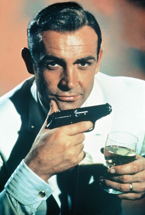 Sean Connery interpretando el papel de James Bond, sosteniendo una copa de vino