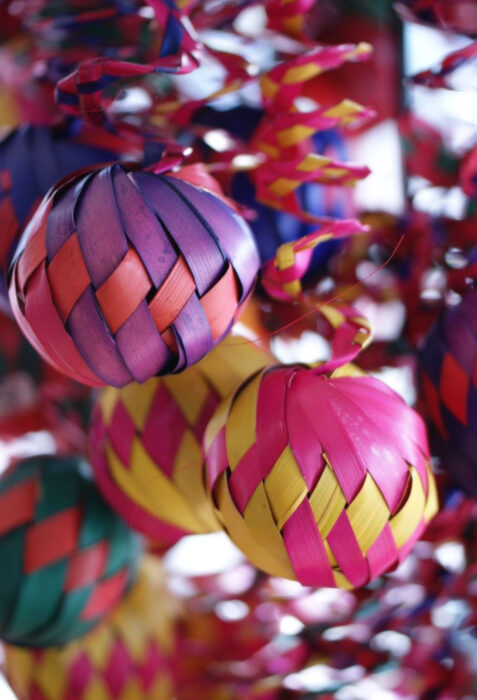 Decoración de Navidad con temática mexicana; esferas de hoja de palma de colores morado, anaranjado, rosa y amarillo, árbol navideño