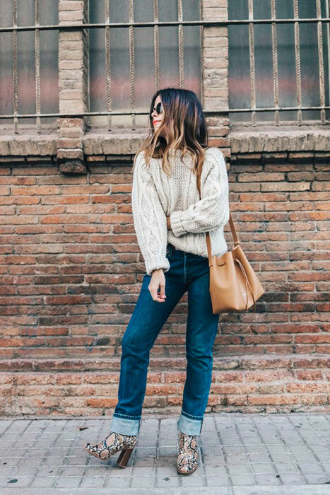 Chica usando botas pitón con jeans suéter color beige y bolso color caki