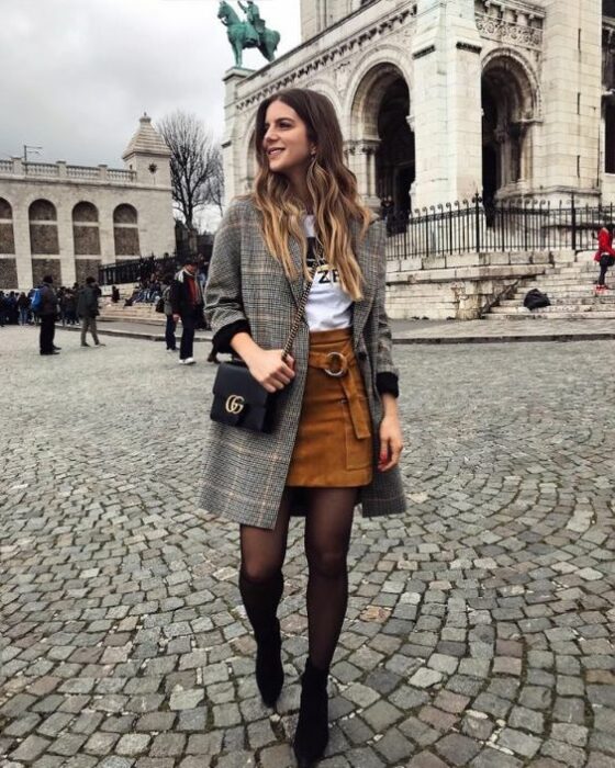 Outfit para la oficina de otoño-invierno de abrigo gris, blusa blanca, minifalda color camel y medias y botines negros