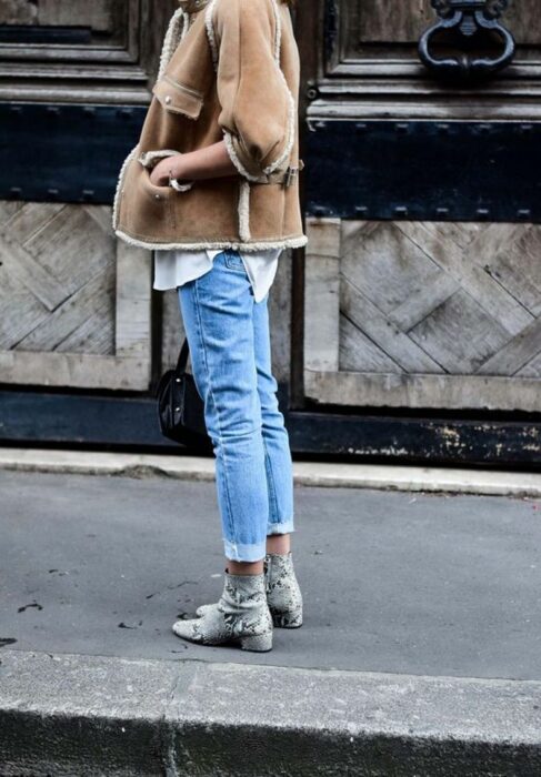 Chica usando botas pitón con jeans, camisa y chaqueta de color caki