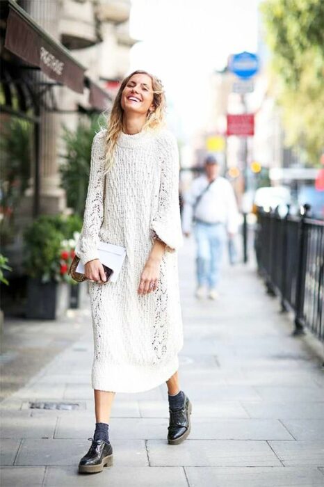 Chica usando un total white look de botines y vestido holgado tejido