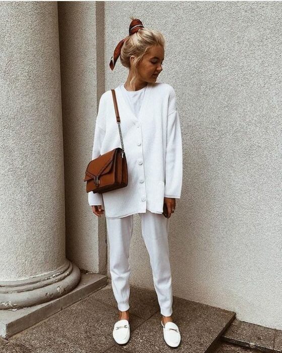 Chica usando un total white look de mules, pantalón, playera blanca y cardigan oversized de botones