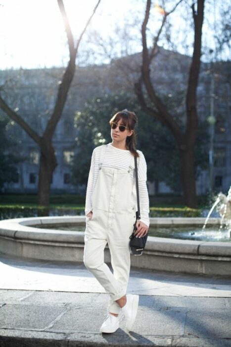 Chica usando un total white look de tenis, pantalón y suéter