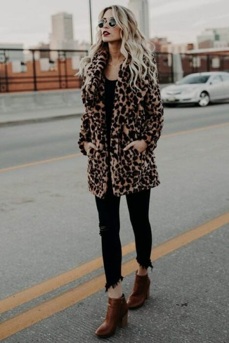 Outfit para la oficina de otoño-invierno de abrigo furry animal print, blusa y jeans negros y botines color camel