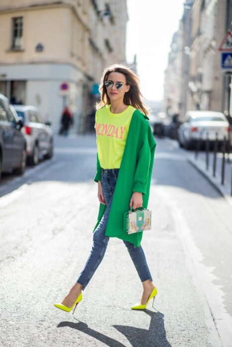 Chica usando una blusa de color amarillo y una gabardina de color verde 