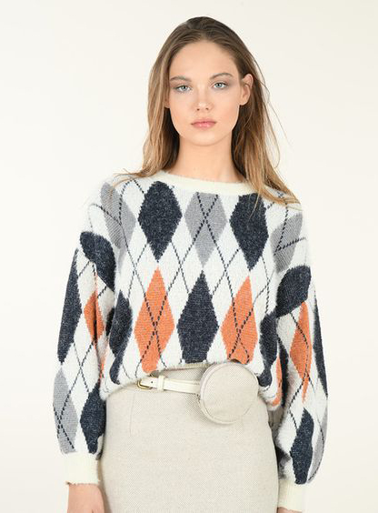 Chica usando un suéter de rombos de varios colores 