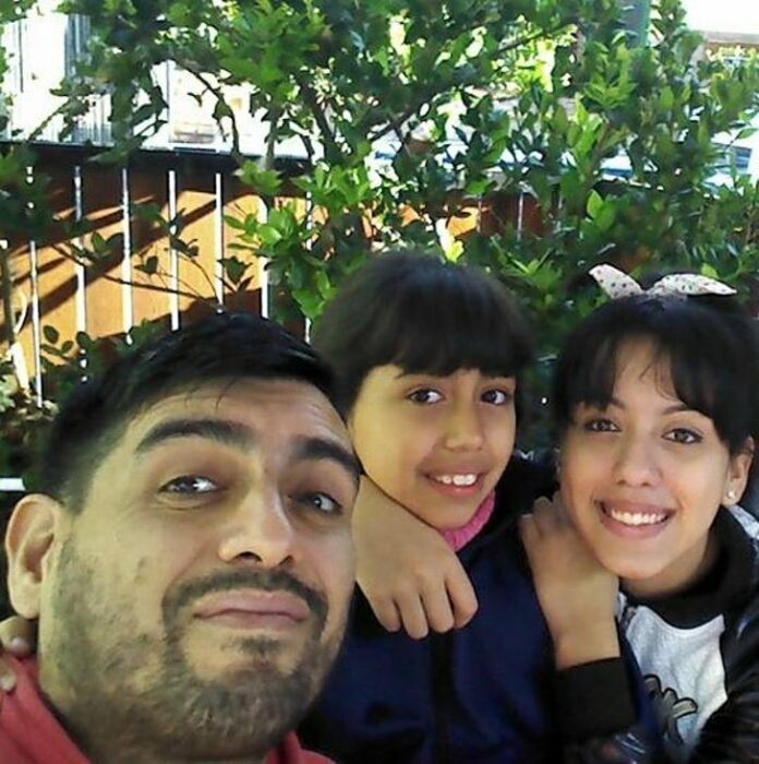 Padre e hijas sonriendo para una fotografía