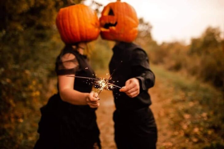 Sesión de foto en pareja con una calabaza en la cabeza