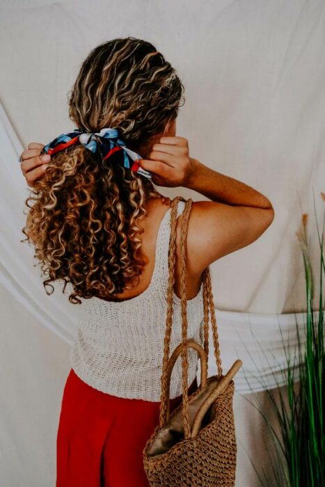 Chica con cabello rizado peinado con una pañoleta