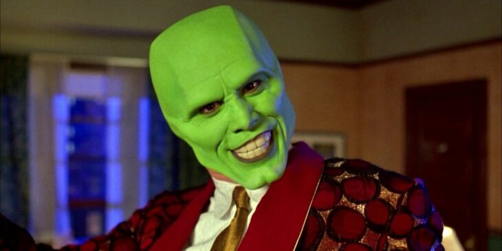 Escena de la película La Mascara. Jim Carrey usando una mascara verde y un traje de color rojo 