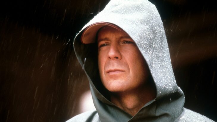 Escena de El Protegido, Bruce Willis parado bajo la lluvia 