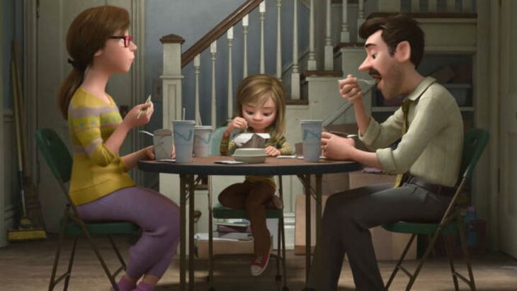 Escena de la película Intensamente. Riley comiendo en una mesa junto a sus padres 