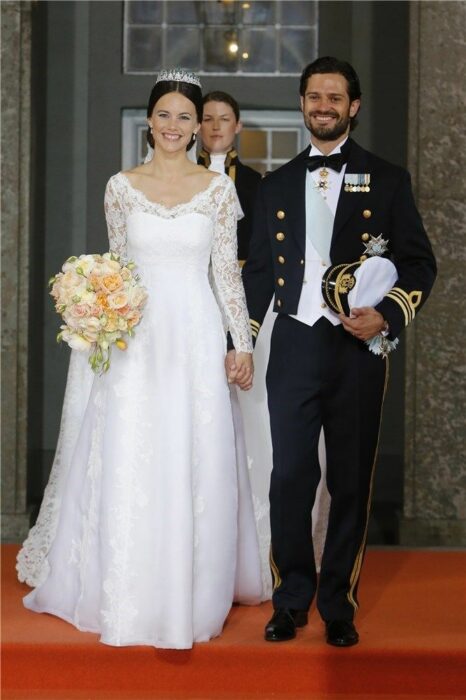 Sofia Cristina de Suecia  el día de su boda luciendo un vestido blanco de encaje con un ramo de novia con flores blancas 