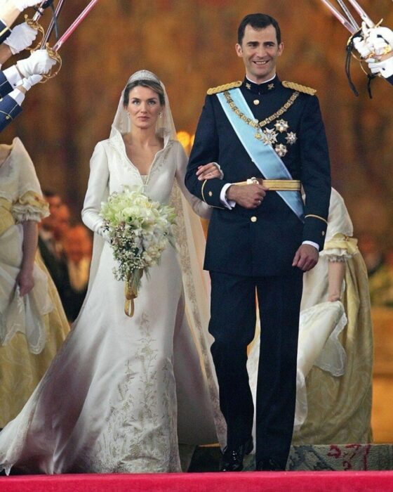 Letizia de España  el día de su boda luciendo un vestido blanco de encaje con un ramo de novia con flores blancas 