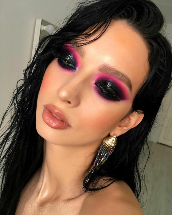 Chica con los ojos maquillados al estilo Smoke Eyes con una línea en color neón rosa 