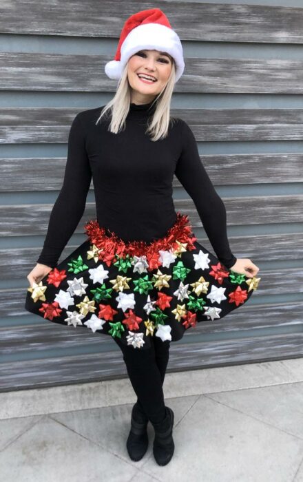 Chica con falda navideña en tono negro con moños de regalo