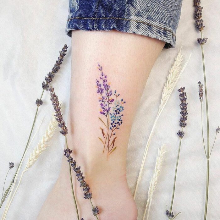 Tatuaje pequeño sobre el tobillo de un ramito de lavanda