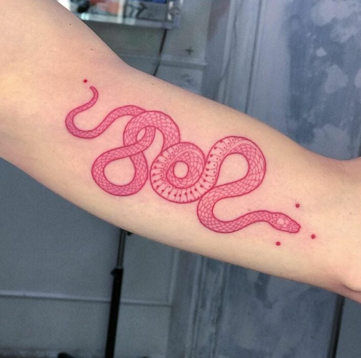 Chica con un tatuaje de color rosa en forma de serpiente 