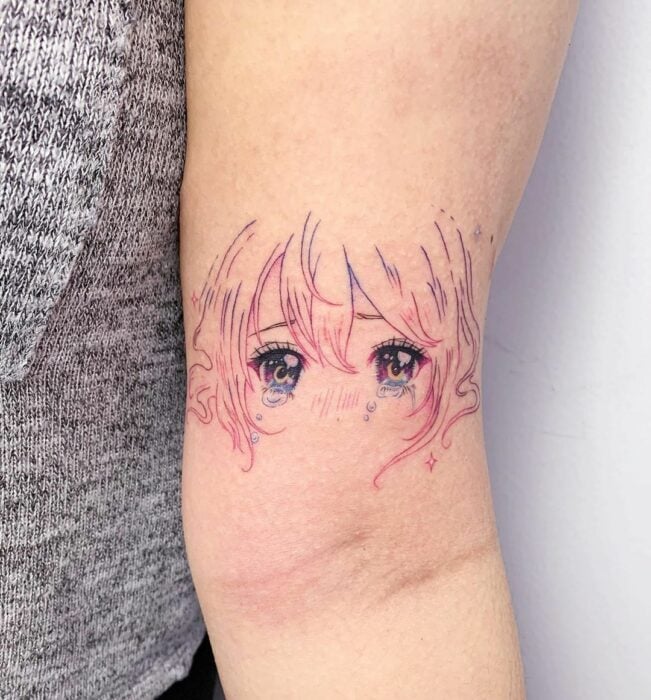 Chica con un tatuaje de color rosa en forma de carita de mueñca
