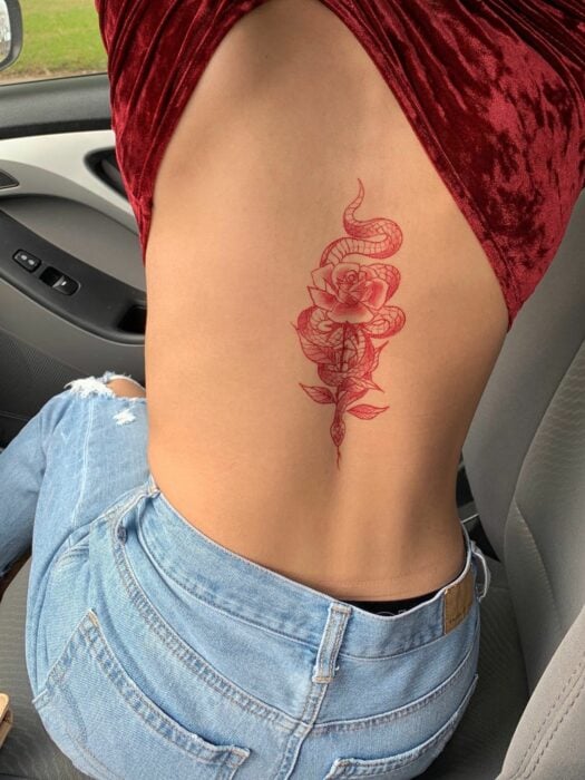 Chica con un tatuaje de color rosa en forma de flores 