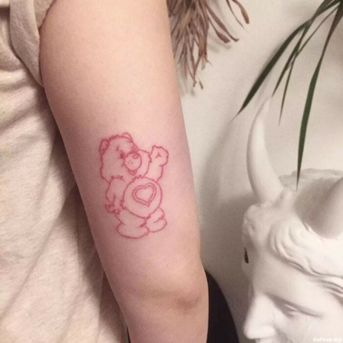 Chica con un tatuaje de color rosa en forma de osito cariñosito