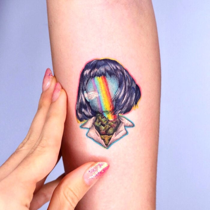 Diseños bonitos de tatuajes de mujer con cara de arcoíris en el brazo