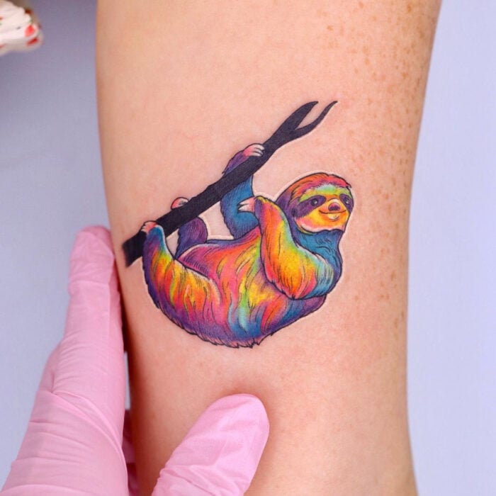 Diseños bonitos de tatuajes de oso perezoso de colores arcoíris en el brazo