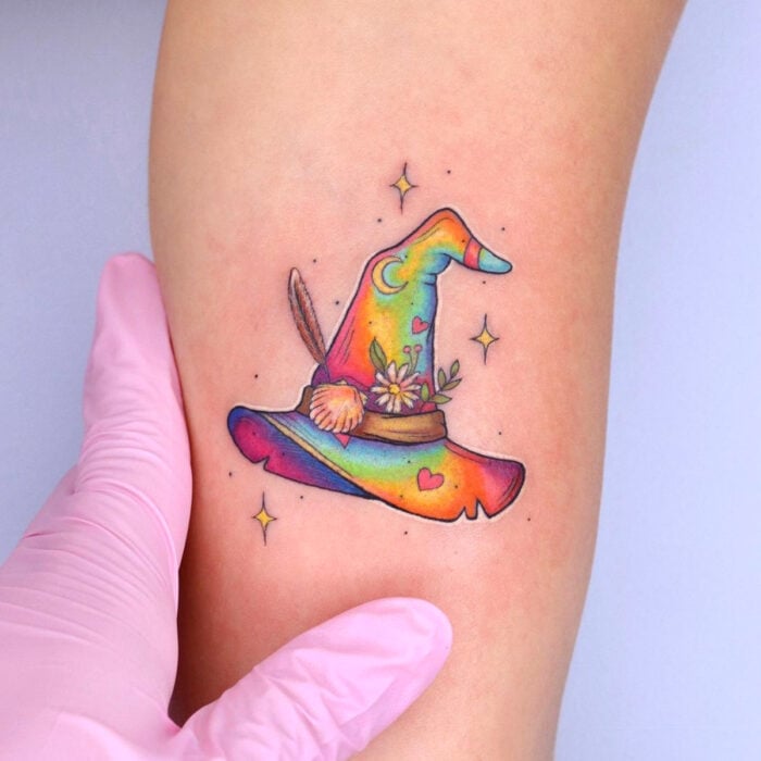 Diseños bonitos de tatuajes de sombrero de bruja de colores arcoíris en el brazo