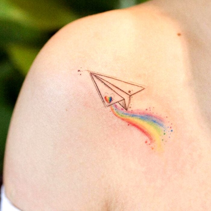 Diseños bonitos de tatuajes de avión de papel de arcoíris en el hombro