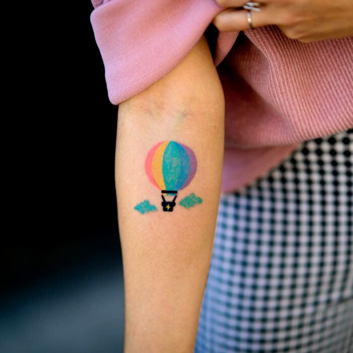 Diseños bonitos de tatuajes de globo aerostático de arcoíris en el brazo