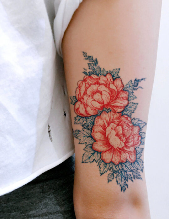 Diseños de tatuajes originales; flores peonias rojas con hojas azules, tatuaje floral en el brazo