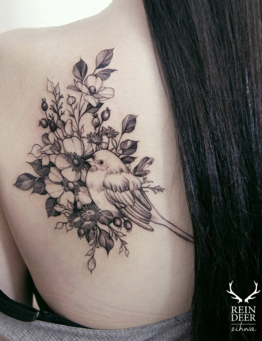 Diseños de tatuajes originales; flores con pájaro; tatuaje de líneas en negro en la espalda