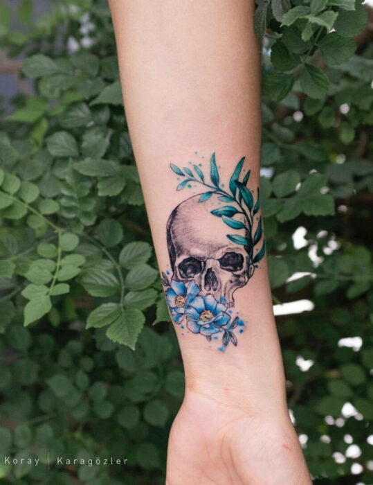 Diseños de tatuajes originales; cráneo con flores, tatuaje en la muñeca