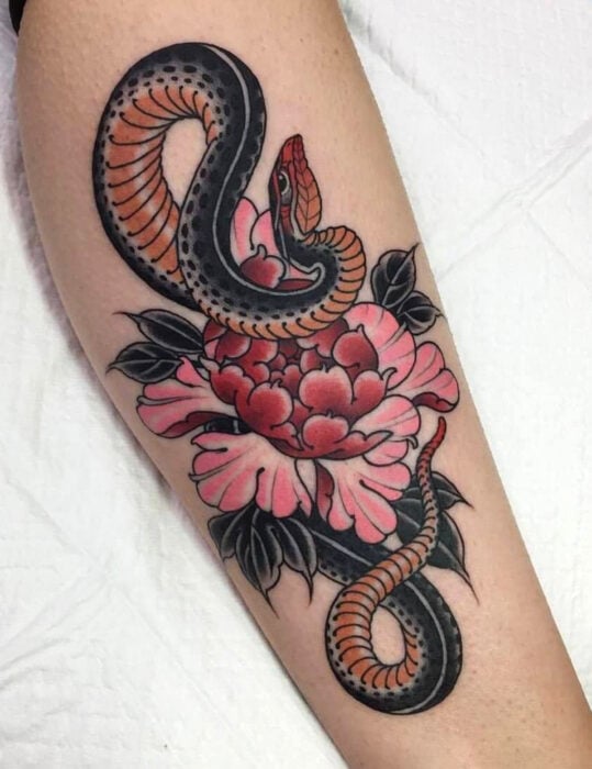 Diseños de tatuajes originales; tatuaje estilo old school, vieja escuela de serpiente con flor peonia en la pierna