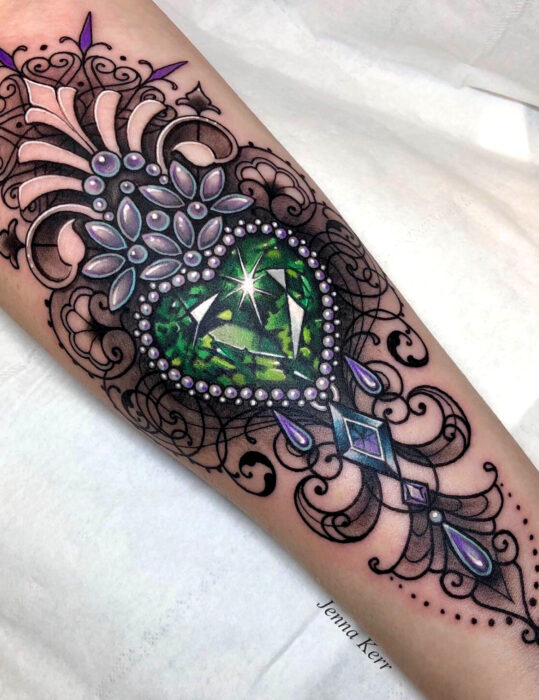 Diseños de tatuajes originales; corazón de cristal verde, tatuaje de joya realista en el brazo