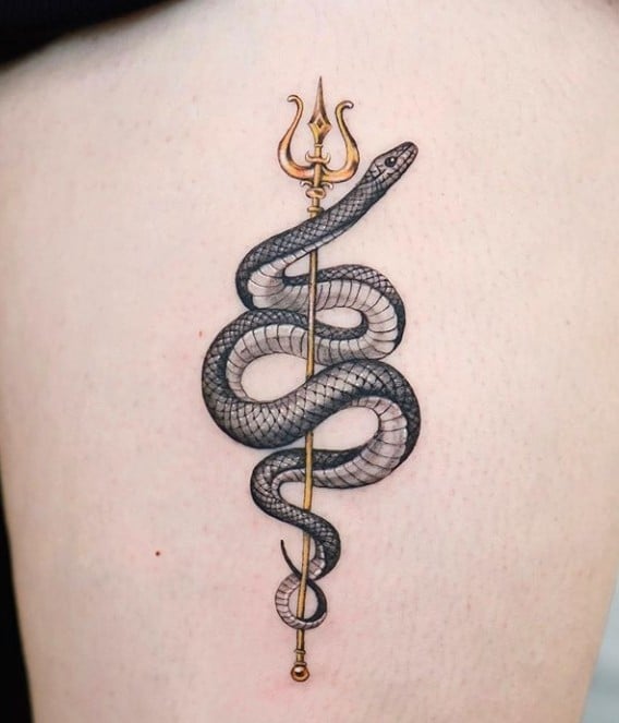 Chica con tatuaje de serpiente sosteniendo un tridente