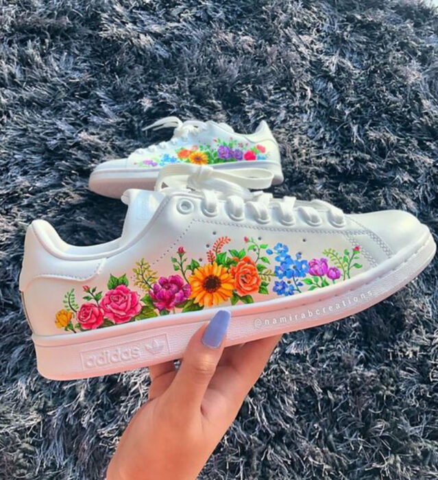 Tenis con flores de diferentes colores pintadas a mano sobre el lateral externo