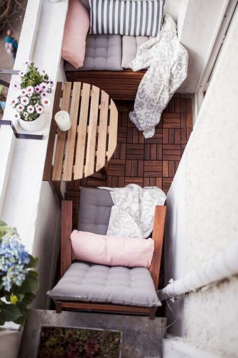 Decoración de terraza en colores rosas, y blancos, con detalles en madera